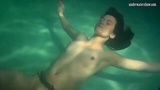 Red dressed mermaid Rusalka swimming in the pool